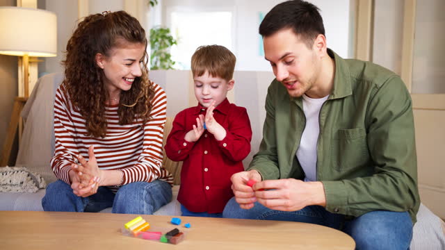 Caucasian father, mother and son playing with child's play clay