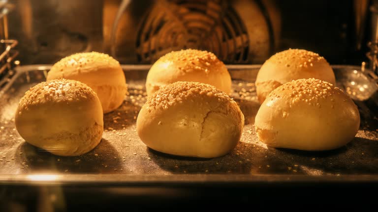 Buns baking in oven. Fresh buns with sesame. Bun for hamburger rising up in oven