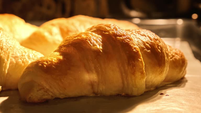 Homemade croissants baking in kitchen oven. Freshly baked croissants.