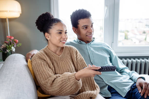 istock Couple sitting on sofa and watching a movie 1473768696