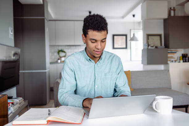 istock Young man working on the laptop at home 1473768722