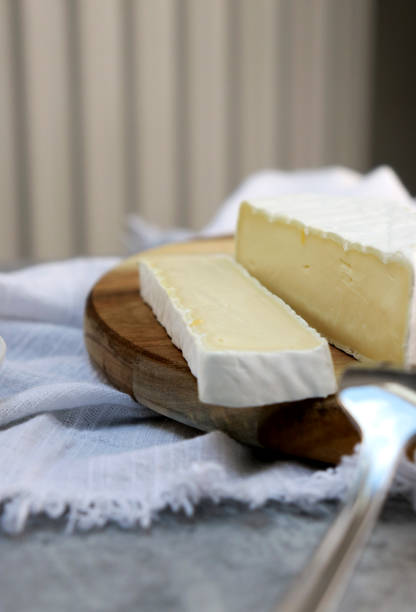 istock delicious brie cheese with cut slice on wooden plate, white background with copy space 1473770400