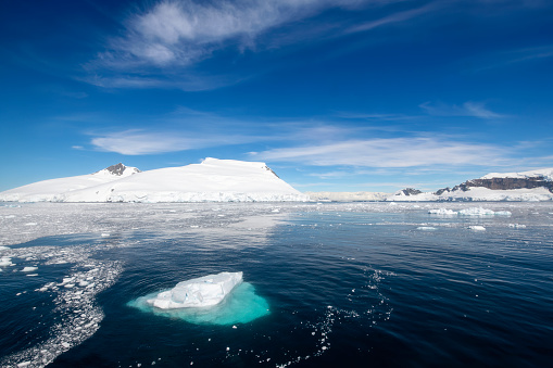 atmospheric landscape in Freud Passage with icebergs and small pieces of ice floating in Antarctica