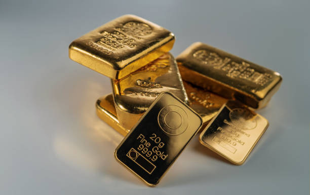 istock Several gold bars of different weight on a grey background. 1473770608