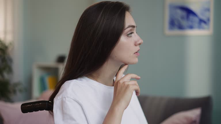 Upset disabled woman puts head on hand thinking about future