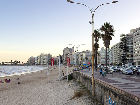 March 15, 2023 - Playa Pocitos in Montevideo, Uruguay. Photo taken of the beach in the evening. There are some people at the beach and on the sidewalk. There is also some grafitti.