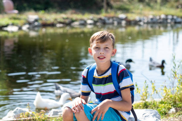 istock portrait of a boy sitting on a rock 1473776331