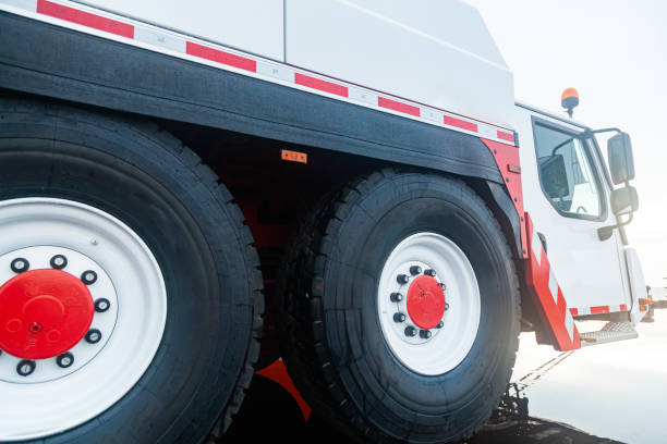 istock Multi-wheel truck crane with white cab and black wheels, close-up. 1473777059