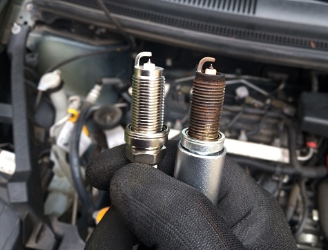 close up of a mechanic that changes spark plugs in a car
