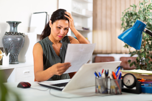 Tired businesswoman working with documents in business office