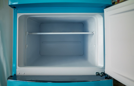 Retro refrigerator freezer with opened door.