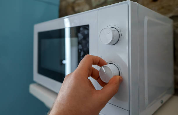 istock Man uses a microwave oven in the kitchen. 1473788302
