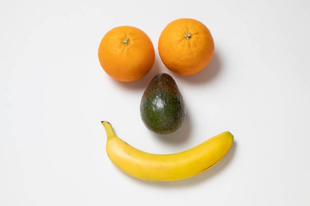 istock A smiling face made with two oranges, one avocado, and one banana, on a white background 1473792973