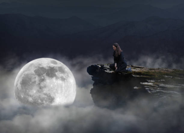 istock A woman sitting on rock against sky 1473796293