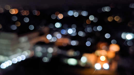 Defocused. Lights of buildings and streets. Blurred background view of the city with magic bokeh for magical effect