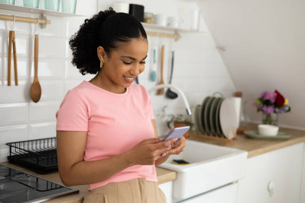 istock Happy young woman using smartphone at home 1473798560
