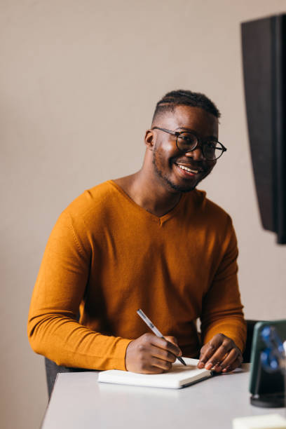 istock A Happy Businessman With Glasses Taking Some Notes In His Notebook While Watching Something On His Computer 1473801239