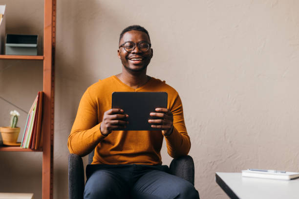 istock A Happy Businessman With Glasses Looking At Camera While Holding His Tablet 1473801242