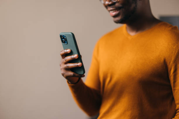 istock An Unrecognizable Happy Businessman Texting On His Mobile Phone 1473801257