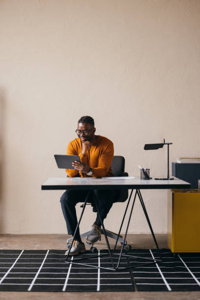 istock A Happy Businessman With Glasses Watching Something On His Tablet 1473801270