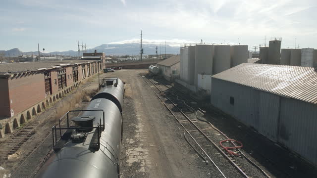 Gas and Oil Equipment Railroad Car Oil Tanks in Rural Small Town America Location in the Western USA Daytime Aerial Video Series