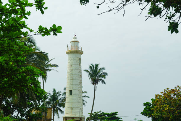 istock Lighthouse of white color among tropical plants 1473806735