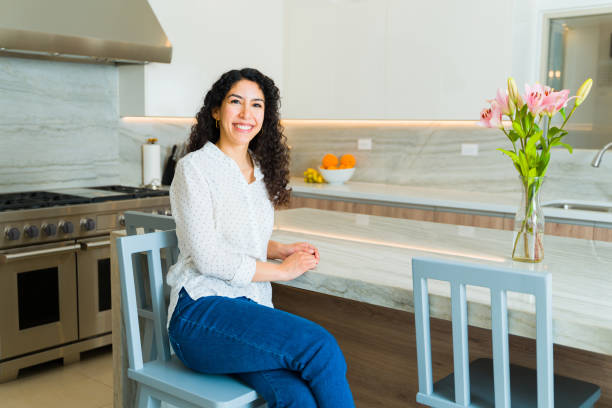 istock Attractive young woman sitting on the granite kitchen island 1473806939