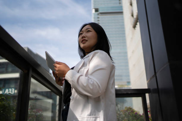 istock Asian business woman using tablet computer outdoors 1473809739