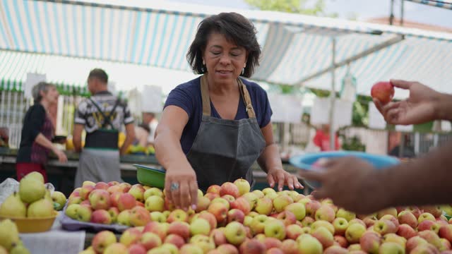 Saleswoman selling apples on a street market