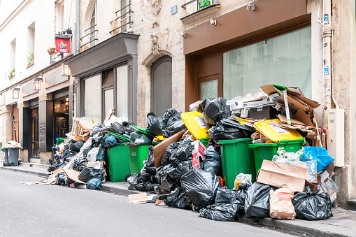 Grève des éboueurs : Full garbage bins during a waste collection strike in Paris, in the chic 6th arrondissement, rue des Canettes, famous for its small restaurants - Neat Saint Germain des Près, Paris in France. March 15, 2023.