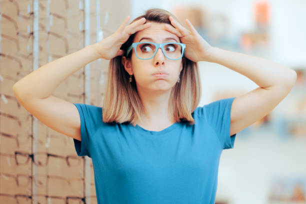 istock Undecided Woman Trying on Different Eyeglasses in Optical Store 1473819909