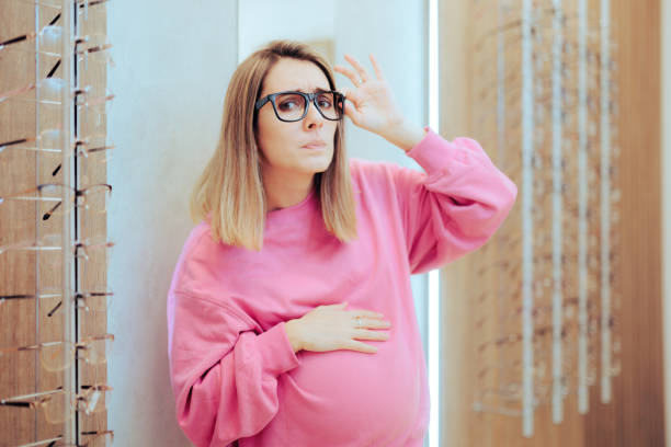 Pregnant Woman Trying New Eyeglasses Having Different Diopters Mother to be complaining about vision problems during pregnancy emotional changes in pregnancy stock pictures, royalty-free photos & images
