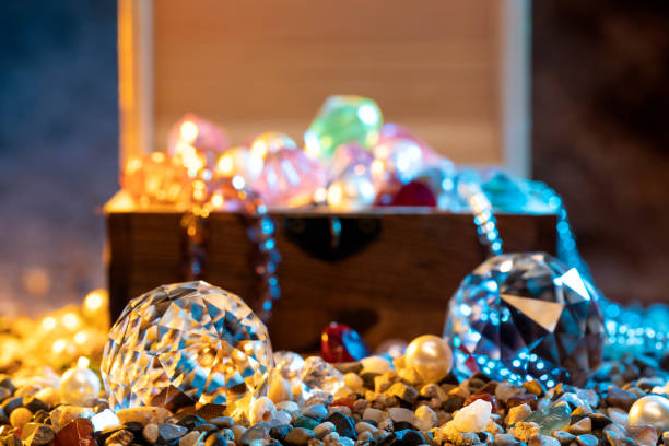 Chest with treasures and scattered sand on wooden table