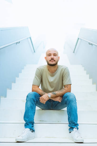Portrait young man sitting on step of staircase.
