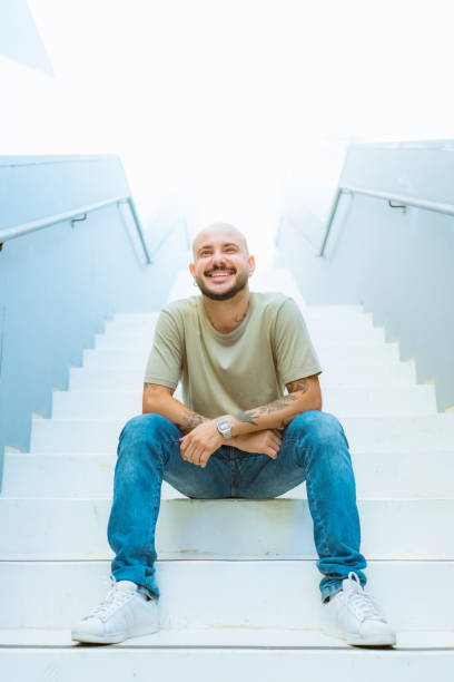 istock Portrait young man sitting on step of staircase 1473824743