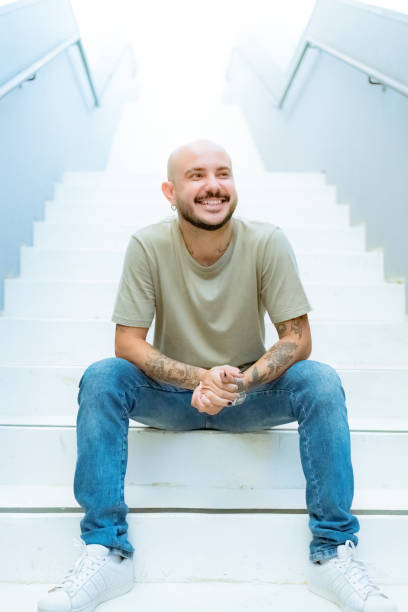 istock Portrait young man sitting on step of staircase 1473825273