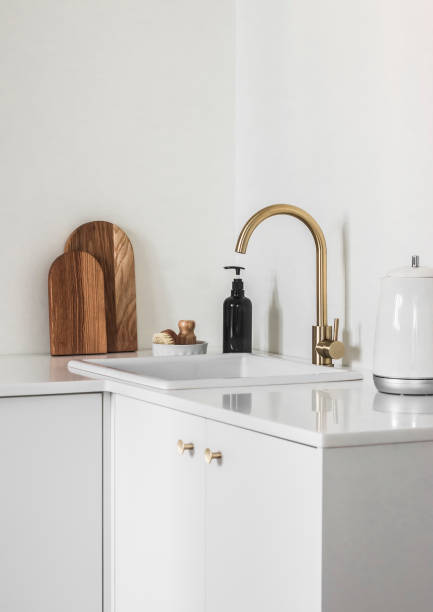 istock Minimalism simplicity kitchen interior - white ceramic sink with dispenser, dish brushes, electric kettle on a white table 1473827886