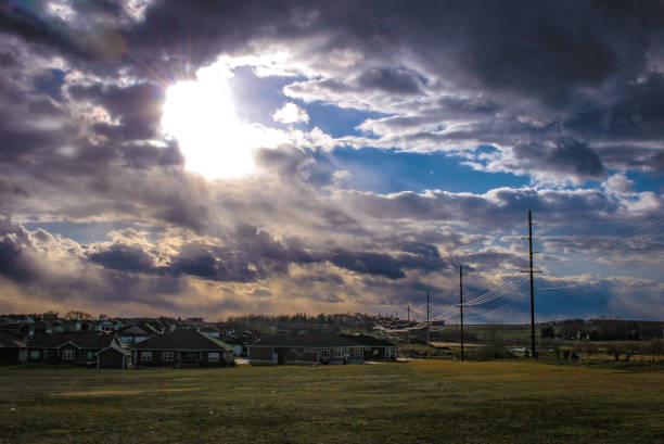 rayos de sol a través del cielo nublado sobre la ciudad - cedar falls iowa fotografías e imágenes de stock