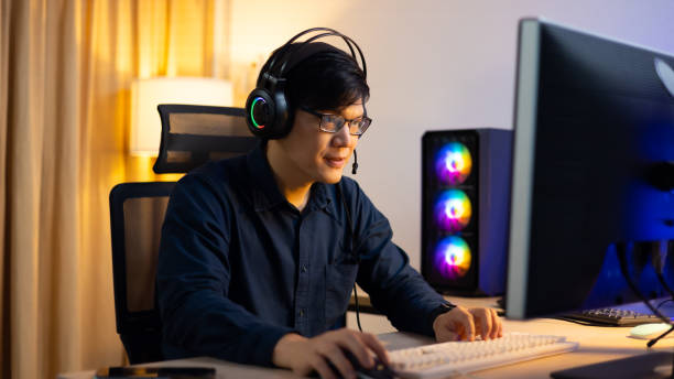 istock Happy excited successful businessman in modern home office with headphone  desktop computer, success happy pose. Work from home and social distancing concept 1473830476