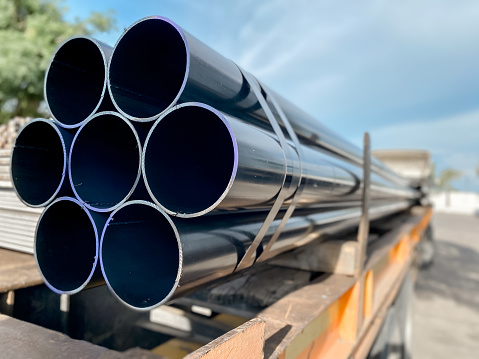 High-quality black steel pipes or stainless steel, aluminum and chrome pipes piled up in warehouses waiting to be delivered.