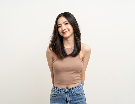 Beautiful smiling happy young asian woman age around 25 in brown shirt. Charming female lady standing pose on isolated white background. Asian cute people looking camera confident with white backdrop.
