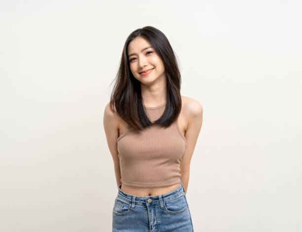 Beautiful smiling happy young asian woman age around 25 in brown shirt. Charming female lady standing pose on isolated white background. Asian cute people looking camera confident with white backdrop. Beautiful smiling happy young asian woman age around 25 in brown shirt. Charming female lady standing pose on isolated white background. Asian cute people looking camera confident with white backdrop. women beautiful studio shot isolated on white stock pictures, royalty-free photos & images