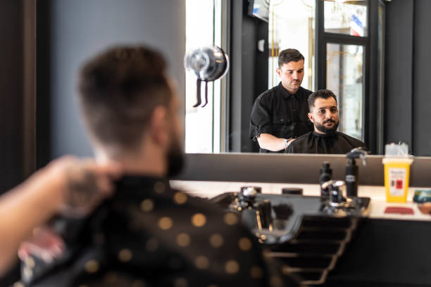 mirror reflection; barbershop man gets a modern shave, beard and hairstyle. preparing haircut - shaving men electric razor reflection imagens e fotografias de stock