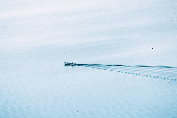 Photo of The old man and the sea. Aerial view of a lonely fishing boat on the vast expanses of the sea or lake. Psychological concept