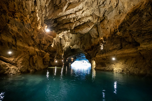 Scenic lake in dark cave. Speleology and travel concept