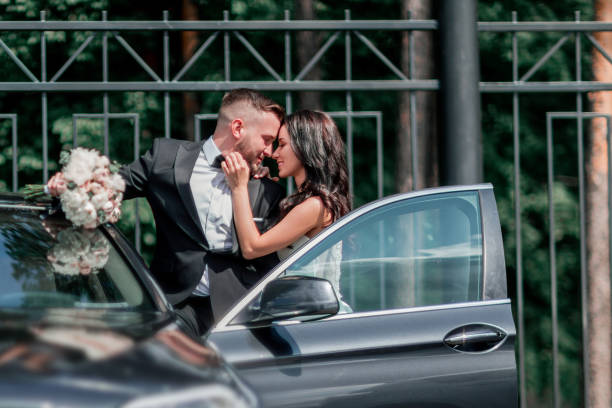 aus nächster nähe. braut und bräutigam stehen in der nähe des autos - bride caucasian wedding ceremony close up stock-fotos und bilder