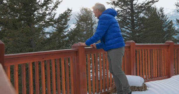 istock Mature man enjoys mandarin orange on cabin veranda 1473844342