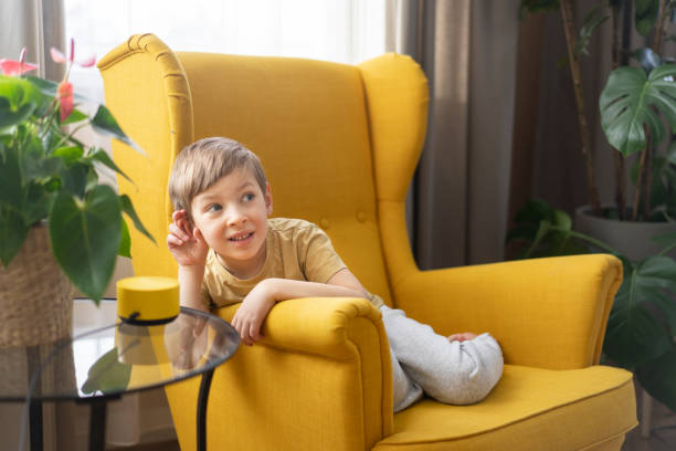 istock A little boy sits in a chair and communicates with a smart speaker 1473845175