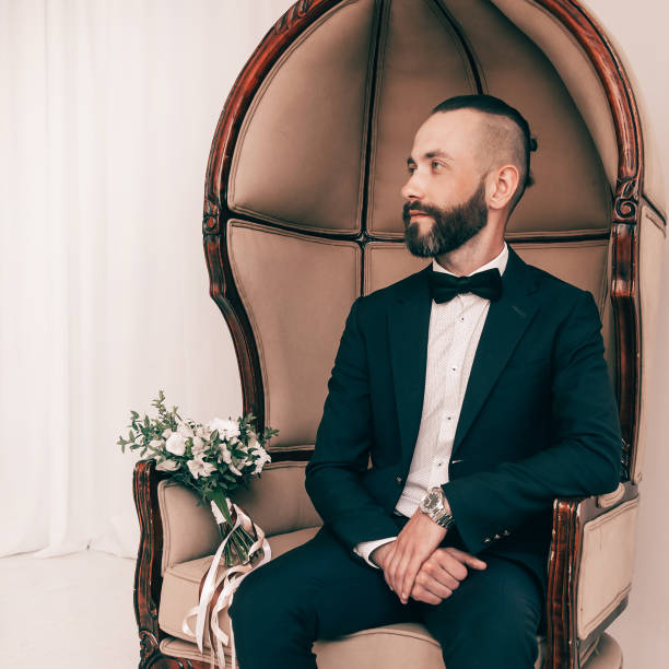 istock in full growth. elegant man sitting in a chair 1473848846