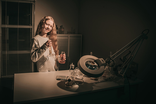 teenager girl standing in a chemistry classroom . the concept of education and hobby